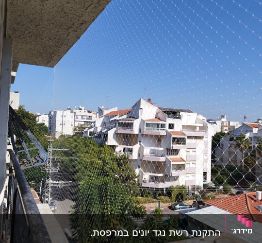 רשת הגנה נגד יונים מותקנת במרפסת בניין